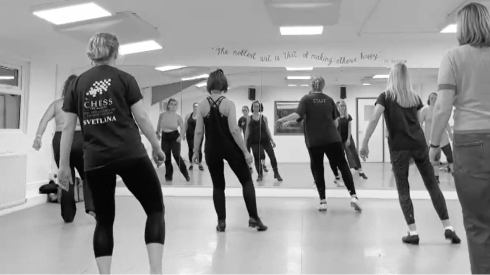 Monochrome picture of a group of women practicing tap dance in a studio