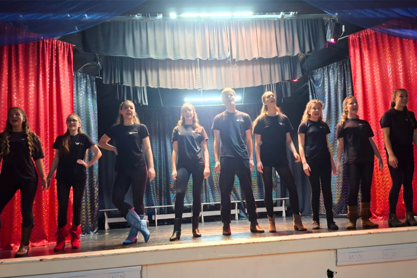 a lineup or young people on stage rehearsing the play
